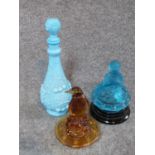 Two antique glass flower frog centre pieces, one in amber glass of a penguin, one frosted blue glass