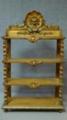A Victorian carved giltwood whatnot with shell and lion mask carving on barley twist supports. H.136
