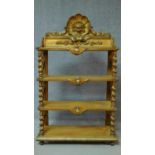 A Victorian carved giltwood whatnot with shell and lion mask carving on barley twist supports. H.136