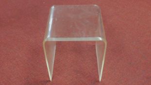 A moulded perspex occasional table. H.43 W.41 D.43cm