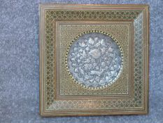 A framed Persian Khatam horn and wood marquetry framed silver and copper repousse plaque with
