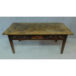 A 19th century oak refectory dining table with three frieze drawers raised on square tapering