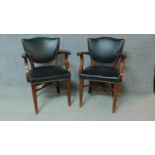 A pair of beech framed office chairs in black faux leather upholstery. H.84cm
