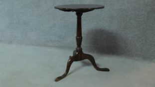 An antique country oak tilt top circular tea table raised on tripod supports. H.67 W.47cm