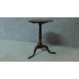 An antique country oak tilt top circular tea table raised on tripod supports. H.67 W.47cm