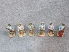 A collection of six antique porcelain hand painted Sitzendorf frog musicians. Includes flute, cello,