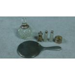 A collection of antique silver items. Including a pepper shaker, napkin ring, silver backed round