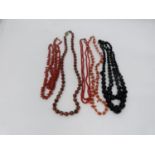 A collection of antique coral and gemstone necklaces. Including a Chinese goldstone necklace with