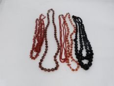 A collection of antique coral and gemstone necklaces. Including a Chinese goldstone necklace with