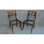 A pair of Regency mahogany carved dining chairs with shell detail raised on sabre supports. (drop in