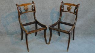 A pair of Regency mahogany carved dining chairs with shell detail raised on sabre supports. (drop in