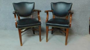 A pair of beech framed office chairs in black faux leather upholstery. H.84cm