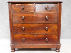 A Victorian mahogany chest of two short over three long drawers, raised on squat turned supports.