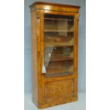 A mid 19th Century burr walnut bookcase with glazed and panelled door enclosing fitted bookshelves