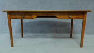 A mid 20th Century teak writing table fitted inset tooled pale green leather top with two frieze