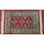 A Persian rug with triple pendant medallions, set on a rouge field with repeating geometric motifs