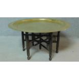 An Eastern decorative brass centre table with carved base. H.45 W.89 D.89cm