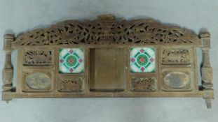 An antique oak Anglo Indian carved headboard fitted with two hand painted tiles. H.47 W.117cm