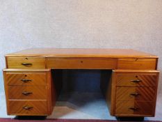 A mid 20th century Art Deco style birch partner's pedestal desk fitted with an arrangement of