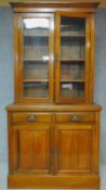 A Victorian oak library bookcase, the upper glazed section above panelled doors on plinth base. H.