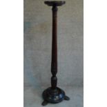 A Victorian mahogany floral carved torchere stand raised on shell shaped feet. H.135cm