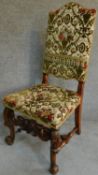 A Victorian carved oak armchair with tapestry style floral upholstery, raised on stretchered
