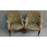 A near pair of Victorian mahogany framed floral upholstered armchairs raised on carved cabriole