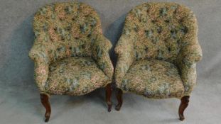 A near pair of Victorian mahogany framed floral upholstered armchairs raised on carved cabriole