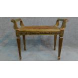 A Victorian gilt stool with caned seat on square tapering supports. H.59 W.69 D.36cm