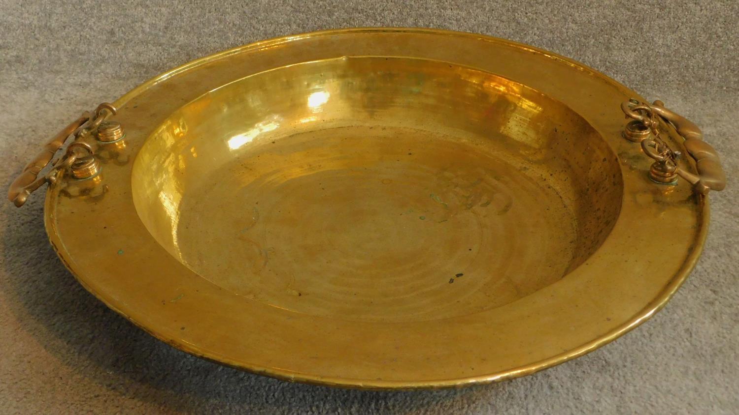 A large Oriental vintage beaten brass bowl with pair of swing handles. 65x65cm