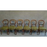 A matched set of six Victorian mahogany carved balloon back dining chairs raised on cabriole legs.