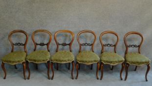 A matched set of six Victorian mahogany carved balloon back dining chairs raised on cabriole legs.