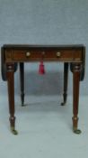 A George IV Cuban mahogany drop flap Pembroke table with frieze drawer raised on tapering reeded