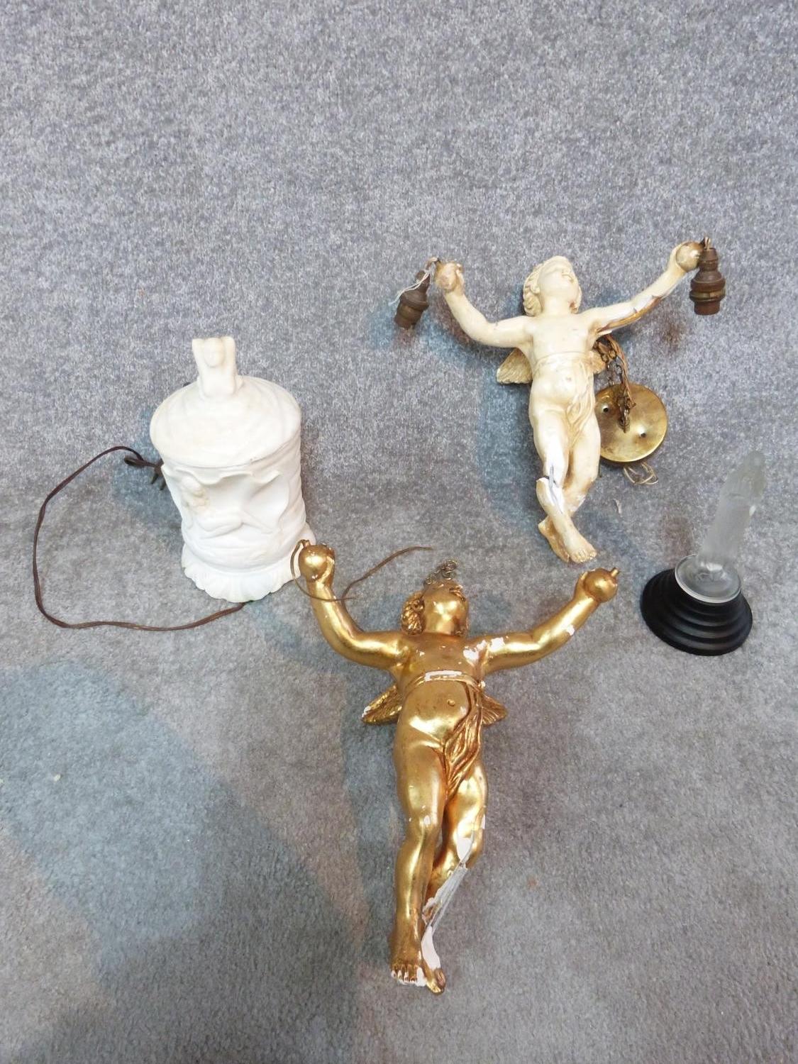 A collection of items, including two plaster cherub light fittings, one gilded, a carved alabaster