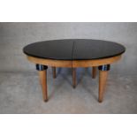 A Continental Art Deco bird's eye walnut extending D end dining table with ebonised top and two