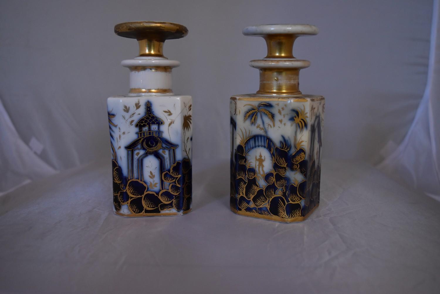 A pair of blue and white French porcelain scent bottles with oriental design and gilded accents.