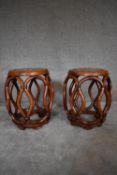 A pair of Chinese rosewood and mother of pearl inlaid barrel shaped stools with latticework sides.