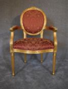 A Louis XVI style gold framed open armchair in rouge damask upholstery. H.104 x 62cm