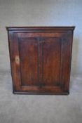 A Georgian oak hanging corner cupboard fitted with panel door. H.97 x 87cm