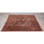 A bokhara style rug with rouge ground and geometric border. H.157 x 134cm