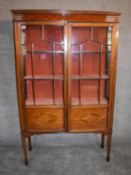 An Edwardian mahogany and inlaid display cabinet with astragal glazed doors on square tapering