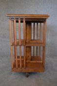 An elm revolving bookcase with inset leather top. H.78 x 48cm