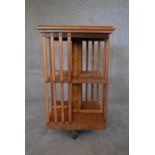 An elm revolving bookcase with inset leather top. H.78 x 48cm