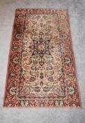 An eastern Kayam rug with a central medallion on a rouge field with repeating petal spandrels and