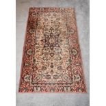 An eastern Kayam rug with a central medallion on a rouge field with repeating petal spandrels and