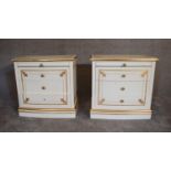 A pair of cream and gilt bedside cabinets fitted two drawers and slide each with plate glass top.