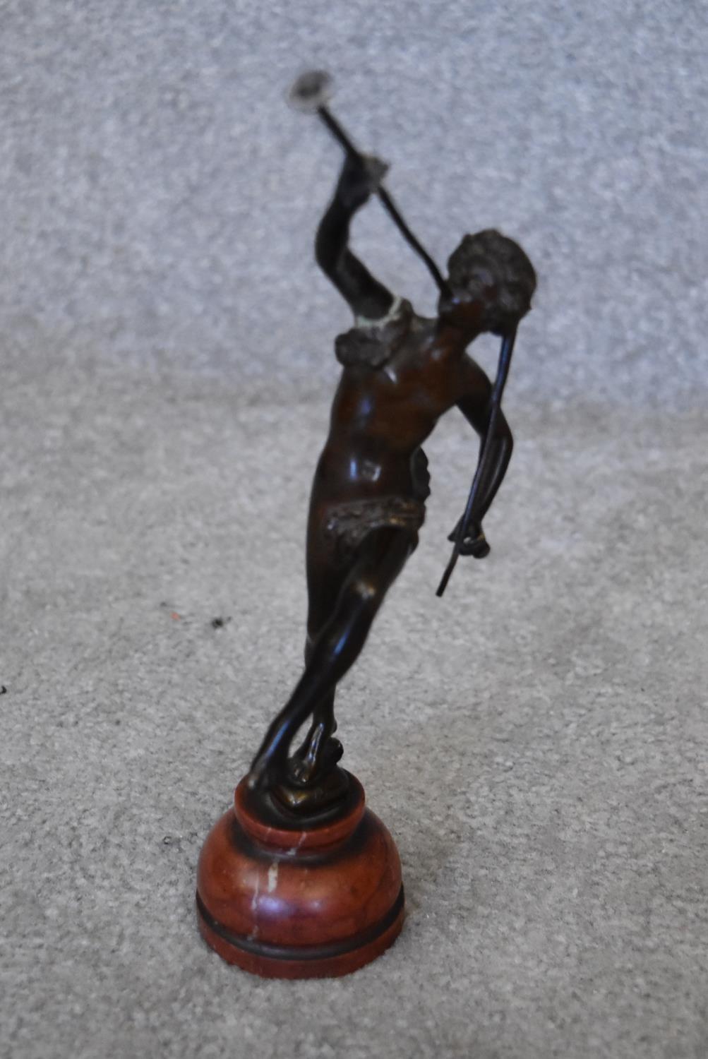 A 19th century bronze figure of Peter Pan on rouge marble circular base, signed. H.15cm