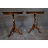 A pair of circular walnut occasional tables on tripod base. 55cm diameter.