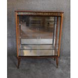 A 1960's vintage display cabinet with a faux rosewood top, fitted glass shelves on dansette legs.