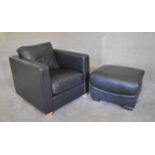 A black leather armchair with matching footstool. Chair: H. 67 x 80cm stool: H.44 x 70cm